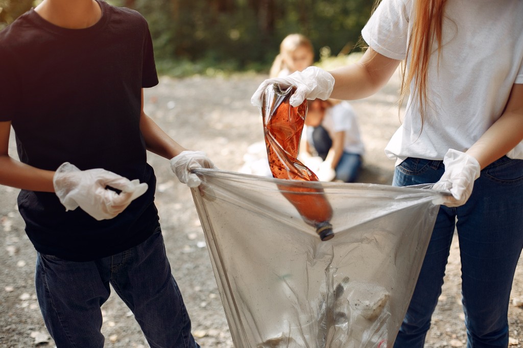 Jugendliche sammeln gemeinsam Abfall in einem Park