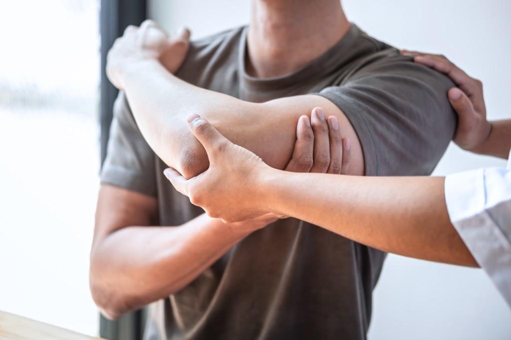 Alle neun Bachelorprogramme sind an eine Ausbildung gekoppelt – sie ersetzen die Berufszulassung nicht. Physiotherapeutin untersucht den Arm eines Patienten in einem hellen Behandlungsraum