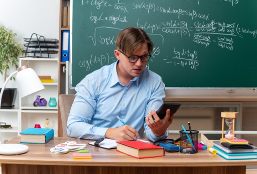 Schreibtisch mit Notizen, Formeln und Smartphone